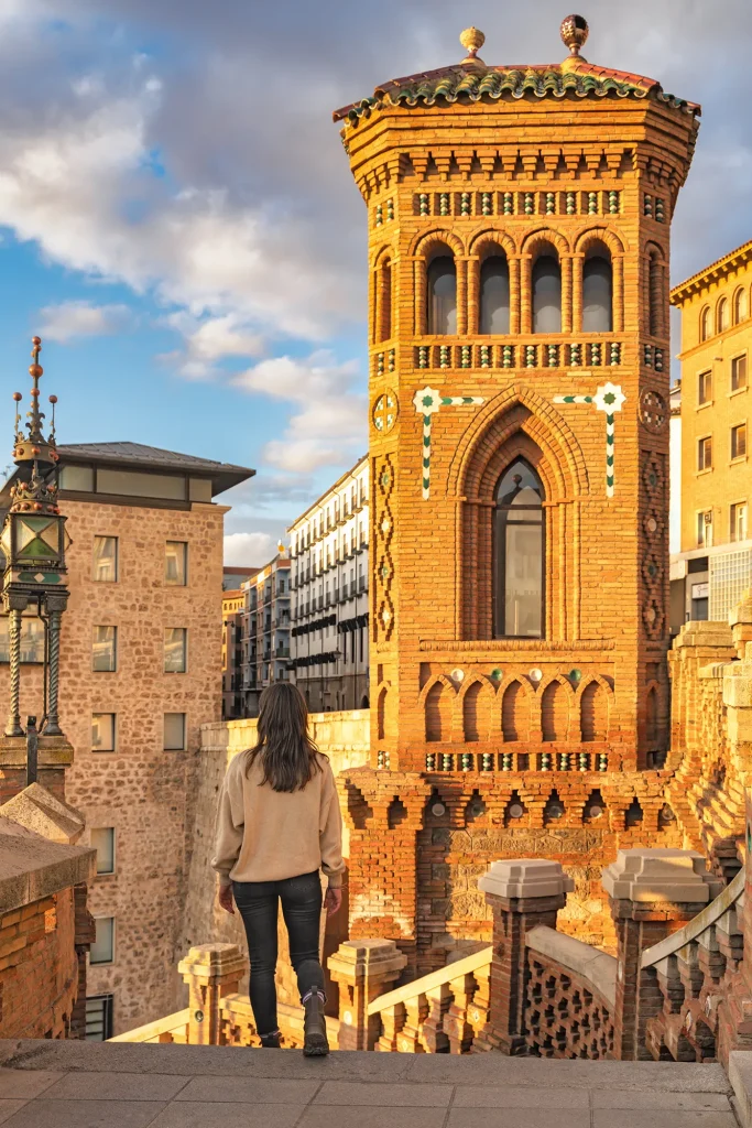 Mujer caminando hacía la torre mudejar en Teruel